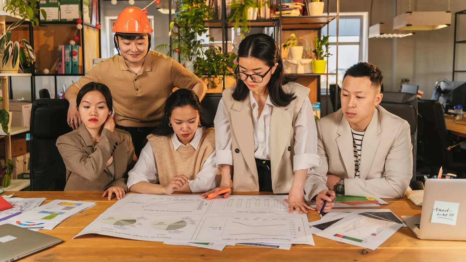 Colleagues reviewing charts and project plans around a desk