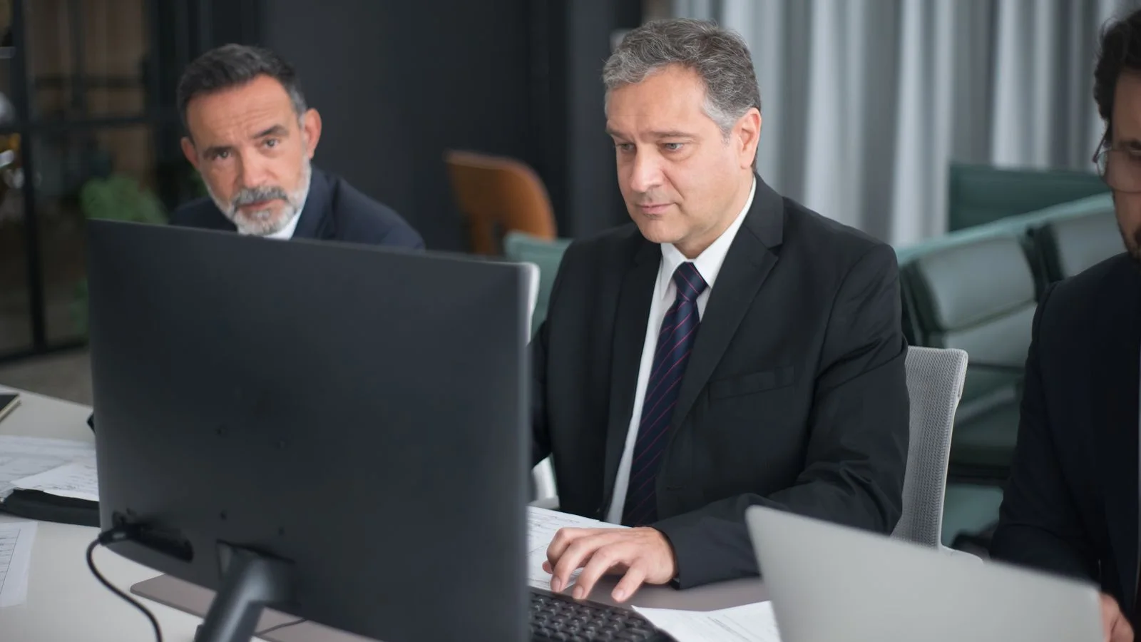 Professionals working with computers in a modern office