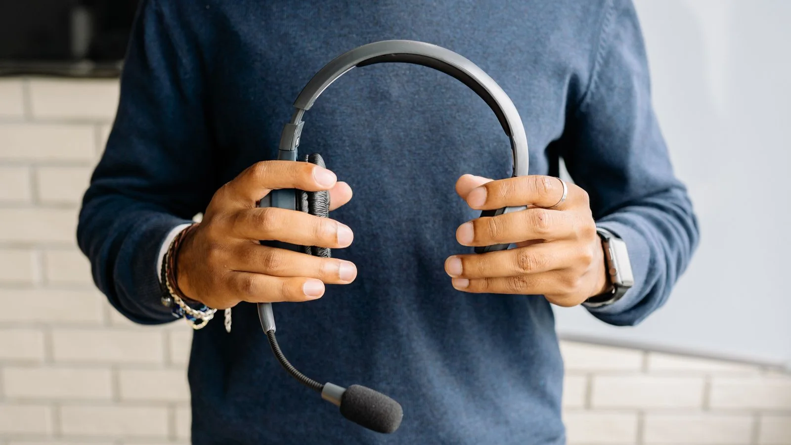 A person holding a headset ready for a customer conversation